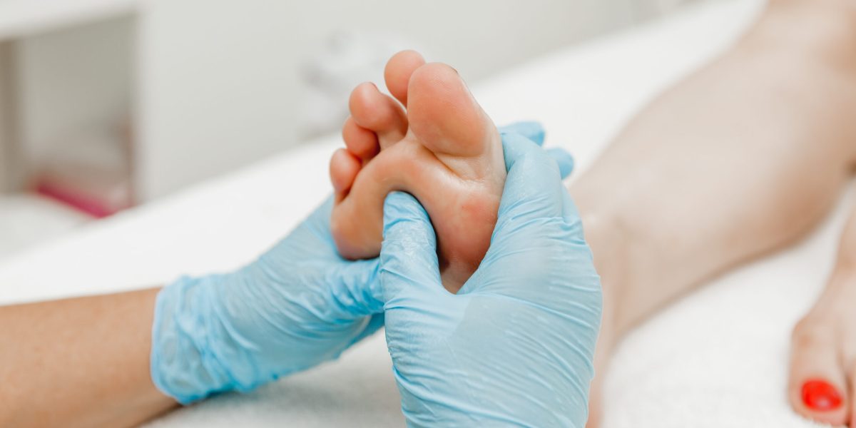 Foot massage in a spa salon, close-up. masseur with gloves massages feet