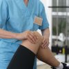 medical-assistant-helping-patient-with-physiotherapy-exercises-scaled-1