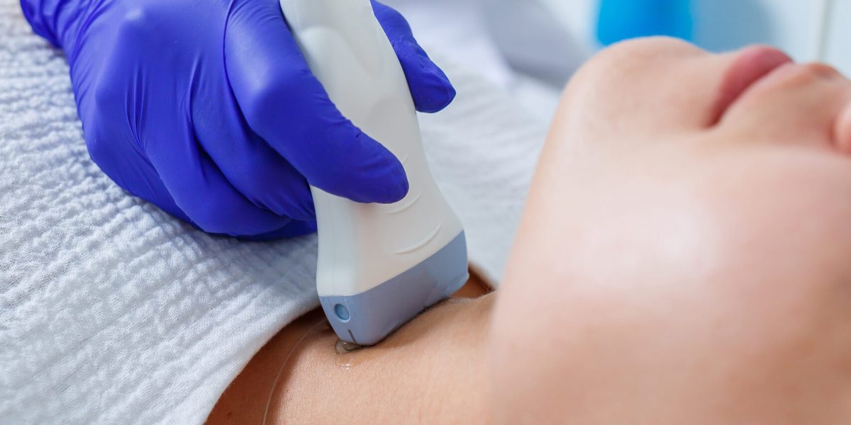 Woman patient reception at a female doctor in a medical center of a modern clinic, gives recommendations of a qualified specialist, health problems. Ultrasound examination of the thyroid gland